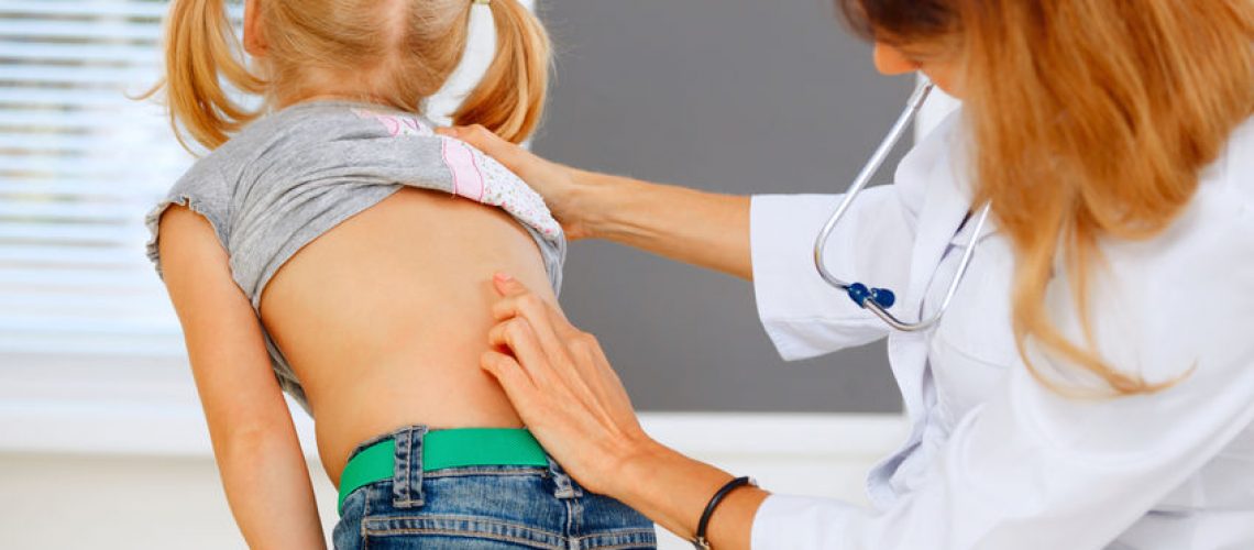 33514610 - pediatrician examining little girl with back problems.